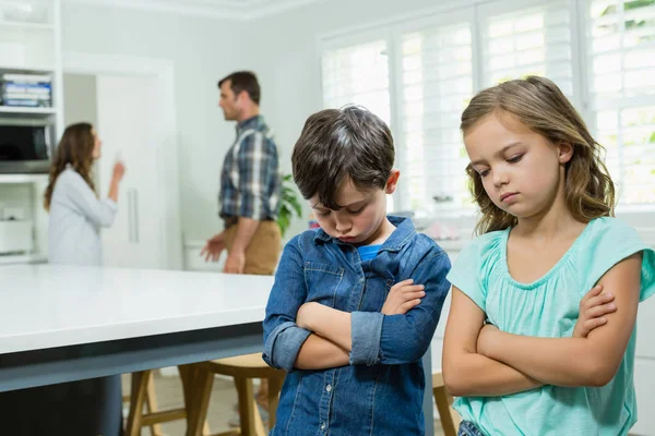 Syskon står medan föräldrar argumentera — Stockfoto