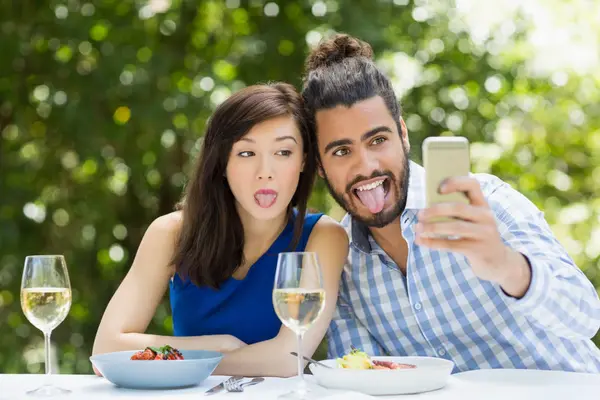 Casal usando tirar uma selfie no telefone celular — Fotografia de Stock