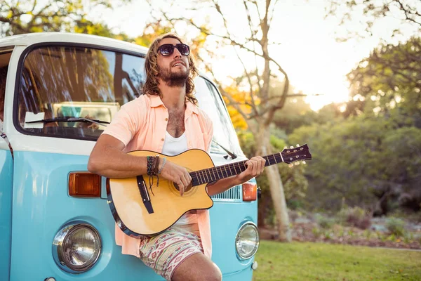 Ο άνθρωπος ακουμπά στον campervan και παίζει κιθάρα — Φωτογραφία Αρχείου