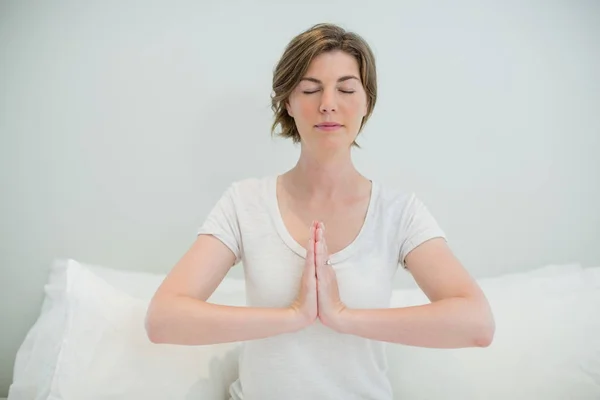 Femme faisant méditation sur le lit dans la chambre — Photo