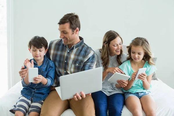 Família usando laptop, tablet e telefone — Fotografia de Stock