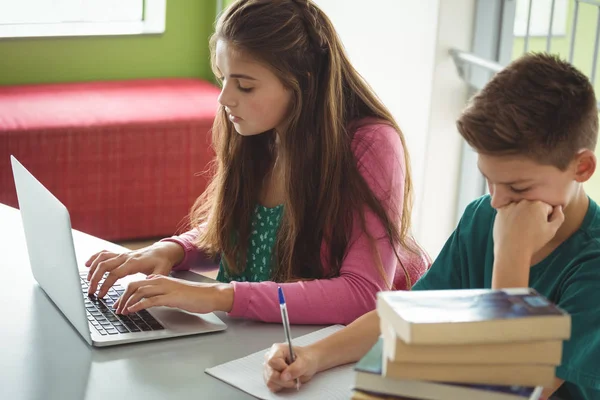 Schulkinder machen Hausaufgaben in der Bibliothek — Stockfoto