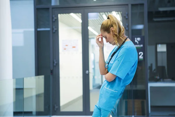 Médico mujer molesto de pie en el pasillo —  Fotos de Stock