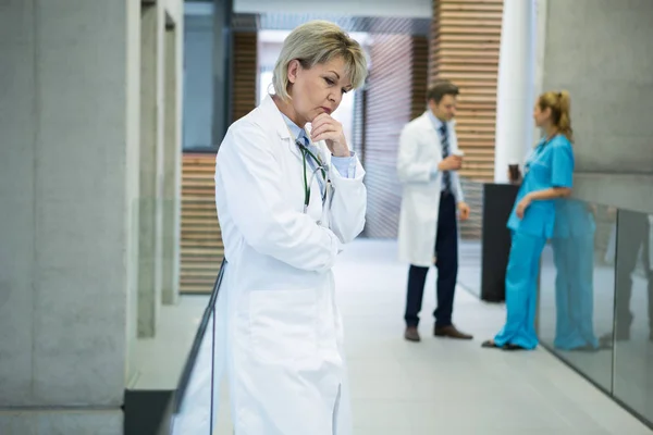 Medico donna premuroso in piedi in corridoio — Foto Stock