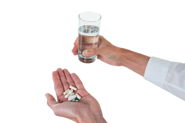 Executivo segurando copo de água e medicamentos — Fotografia de Stock