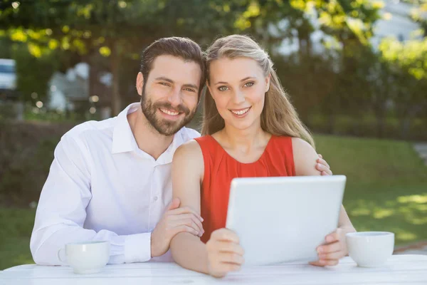 Pareja feliz sonriendo mientras sostiene la tableta digital —  Fotos de Stock