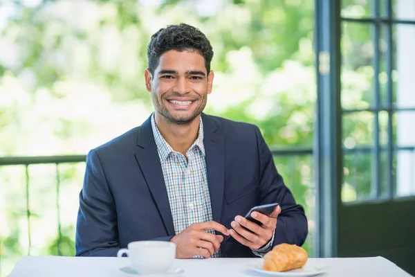 Feliz empresario sosteniendo el teléfono móvil — Foto de Stock