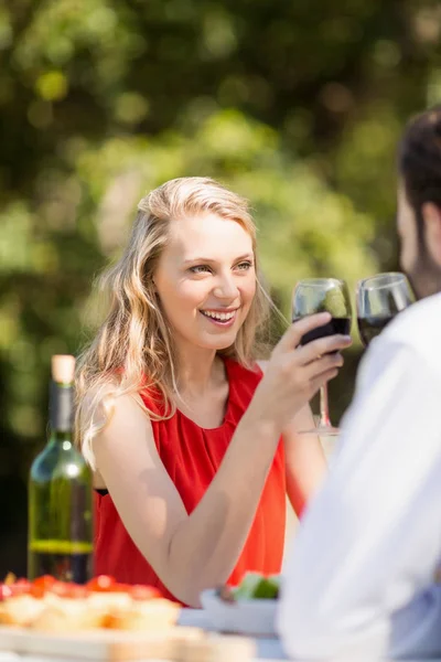 Casal brindar copos de vinho enquanto sentado — Fotografia de Stock