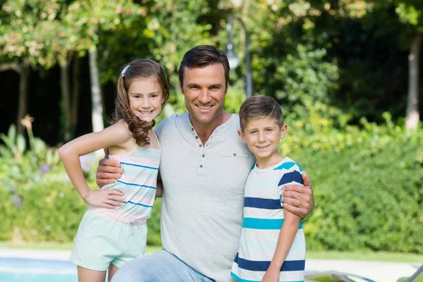Улыбающийся отец с сыном и дочерью в парке — стоковое фото