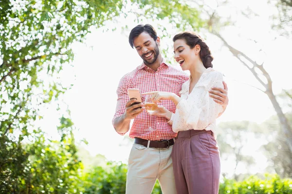 Casal feliz rindo ao usar o telefone móvel — Fotografia de Stock