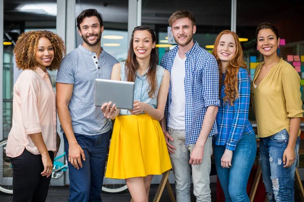 Ejecutivos sonrientes discutiendo sobre tableta digital en la oficina — Foto de Stock