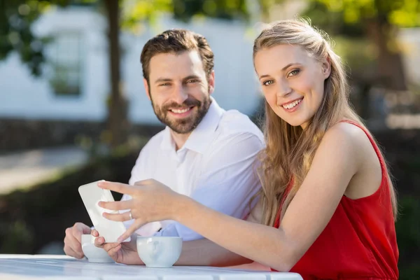 Par med hjälp av mobiltelefon i en restaurang — Stockfoto