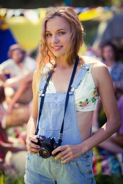 Retrato de mulher segurando câmera no parque de campismo — Fotografia de Stock