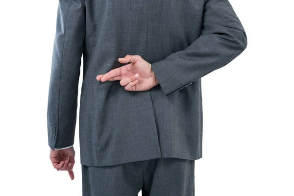 Businessman standing with figure crossed — Stock Photo, Image
