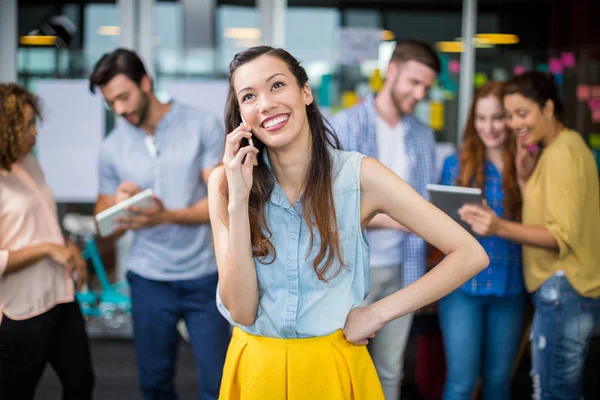 Kadın yönetici cep telefonu üzerinde konuşurken gülümseyen — Stok fotoğraf