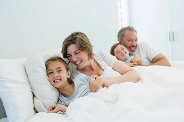 Семья лежит вместе на кровати в спальне — стоковое фото