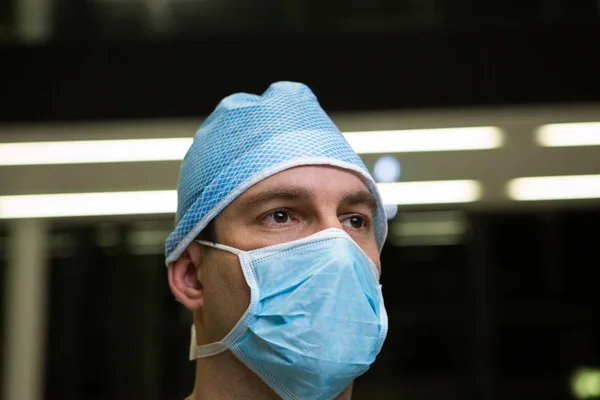 Thoughtful male surgeon wearing surgical mask — Stock Photo, Image