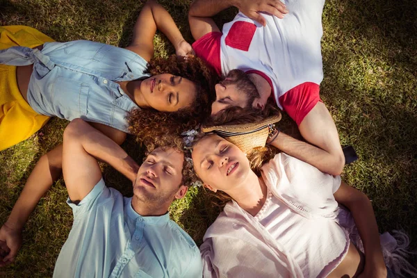 Friends relaxing on grass in park — Stock Photo, Image