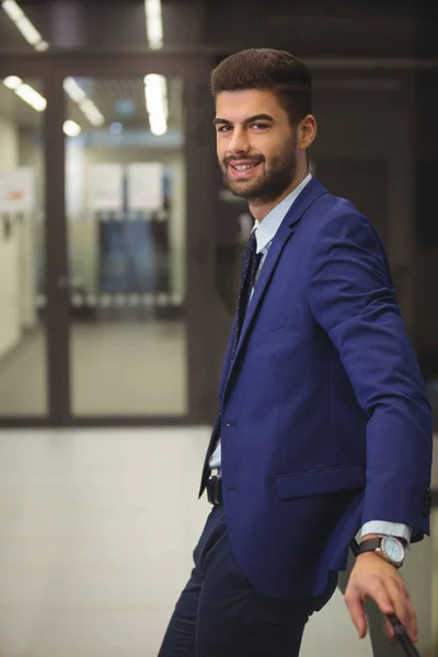 Bonito homem de negócios em pé no corredor — Fotografia de Stock