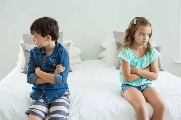 Traurige Geschwister sitzen mit verschränkten Armen — Stockfoto