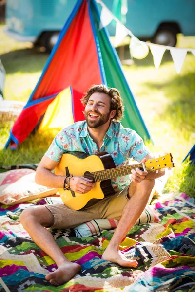 Homem tocando guitarra no acampamento — Fotografia de Stock