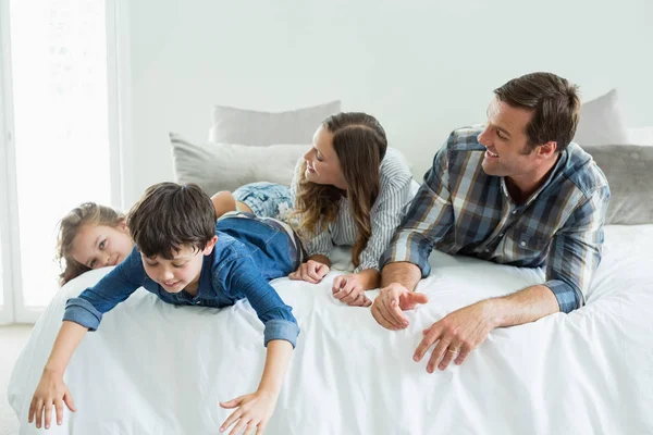 Rodina hraje na posteli v ložnici — Stock fotografie