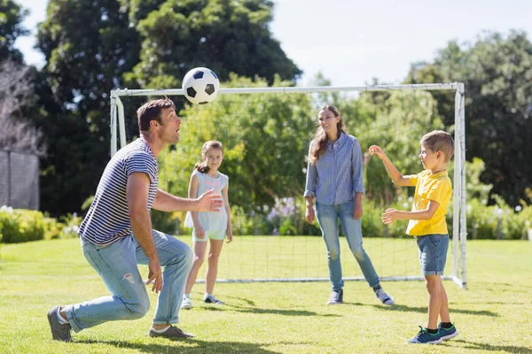 Famille heureuse jouant au football dans le parc — Photo