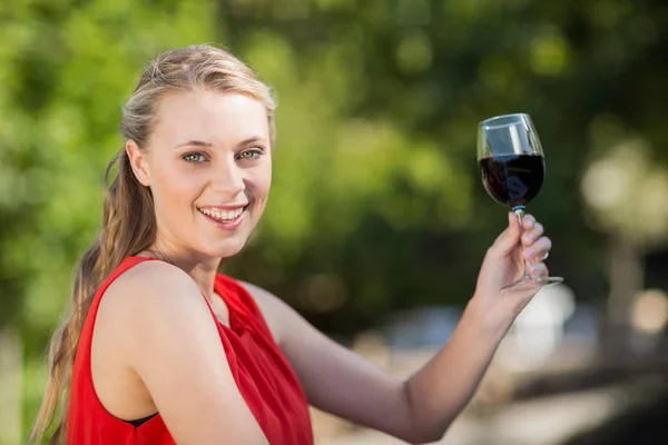 Piękna kobieta trzyma kieliszek wina w parku — Zdjęcie stockowe