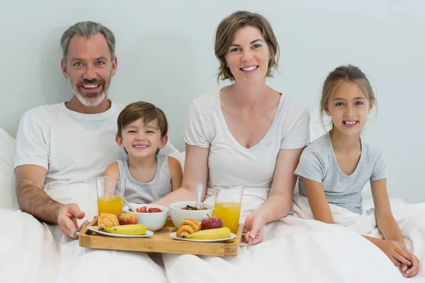 Família tomando café da manhã na cama — Fotografia de Stock