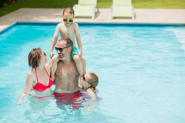 Happy parents and kids in pool — Stock Photo, Image