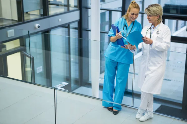 Médico e enfermeiro discutindo sobre um relatório médico — Fotografia de Stock