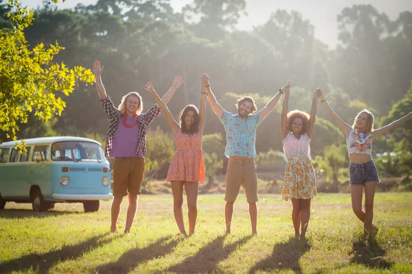 Friends raising their hands in park — Stock Photo, Image