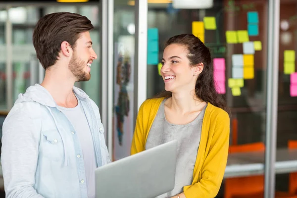 Smiling executives using laptop — Stock Photo, Image