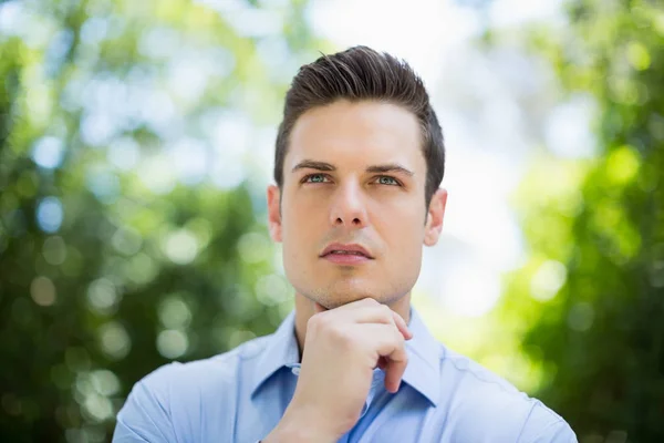 Thoughtful man in park on a sunny day — Stock Photo, Image