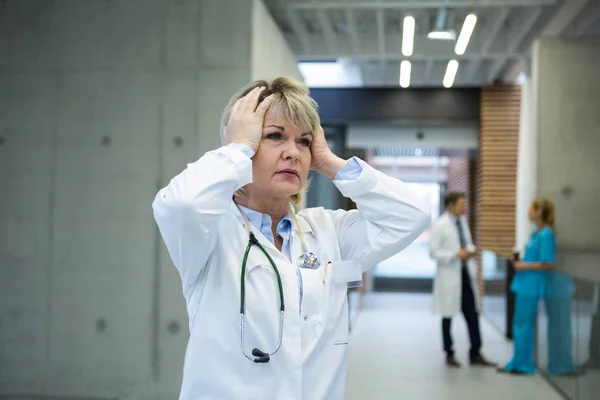 Medico femminile premuroso in piedi n corridoio — Foto Stock