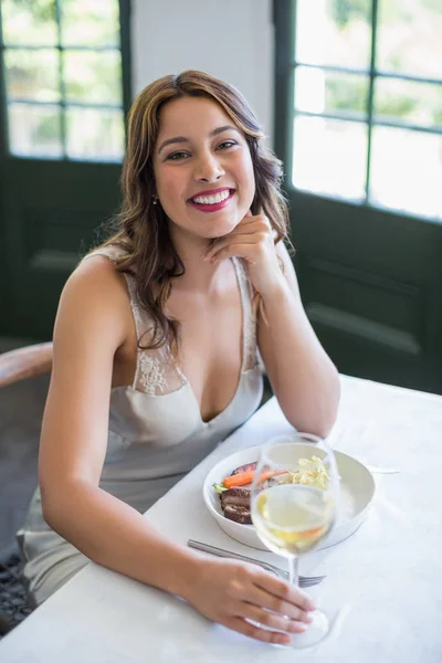 Woman smiling while holding wine glass in the restaurant — Stock Photo, Image