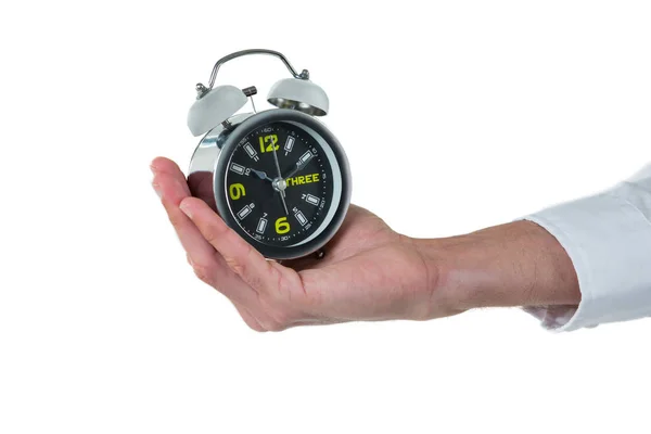 Hand of executive holding alarm clock Stock Image