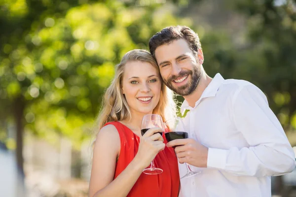 Lyckliga paret håller vin glasögon i parken — Stockfoto