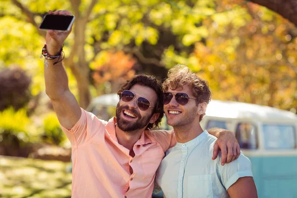 Dois amigos do sexo masculino tomando selfie com telefone celular — Fotografia de Stock