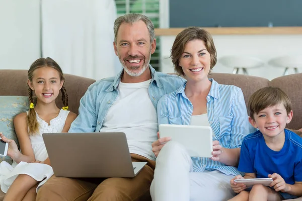 Família usando telefone celular, tablet e laptop — Fotografia de Stock