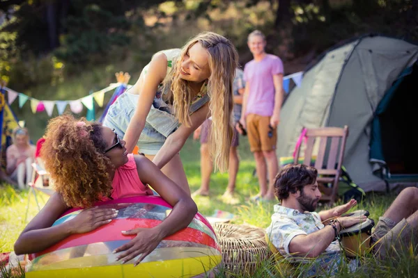 Friends leaning on beach ball at campsite — Stock Photo, Image