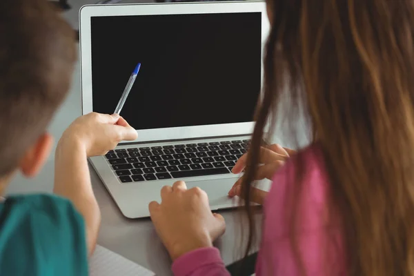 Schoolkinderen met laptop in de bibliotheek — Stockfoto