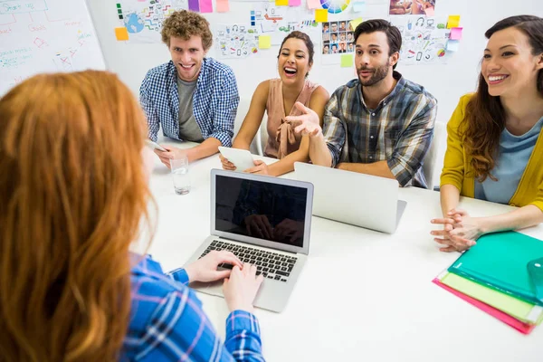 Colegas discutiendo sobre portátil con ejecutivo durante la reunión —  Fotos de Stock