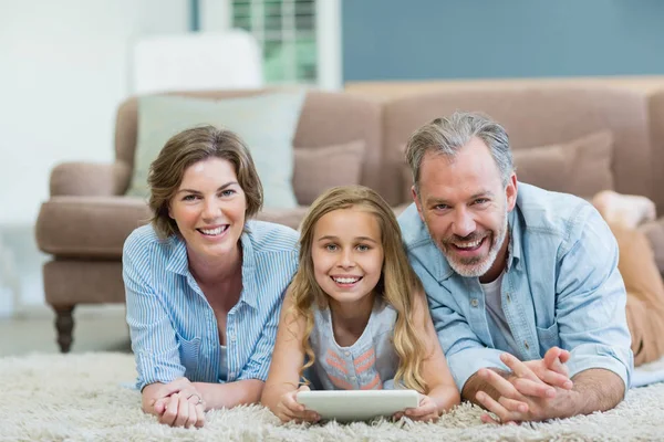 Família usando tablet enquanto deitado no chão — Fotografia de Stock