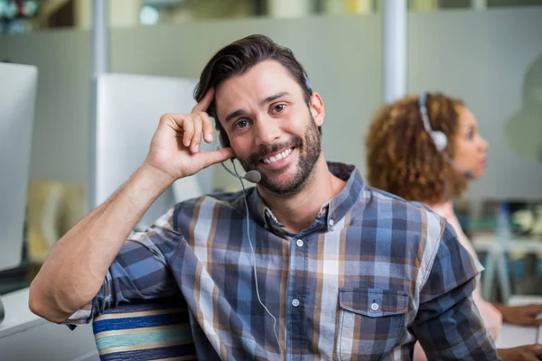 Portrait of male customer service executive talking on headset at desk — Stock Photo, Image