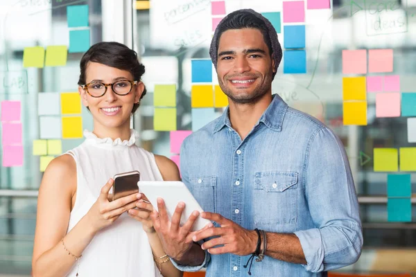 Портрет руководителей, стоящих с цифровым планшетом и мобильным телефоном в офисе — стоковое фото