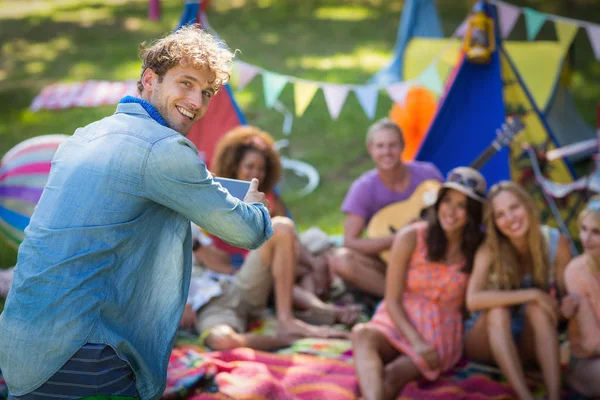 Man taking a picture of friends at campsite — Stock Photo, Image