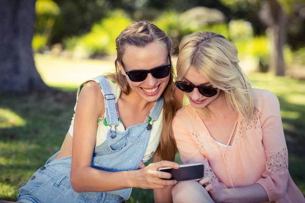 Mulher mostrando telefone celular para seu amigo — Fotografia de Stock