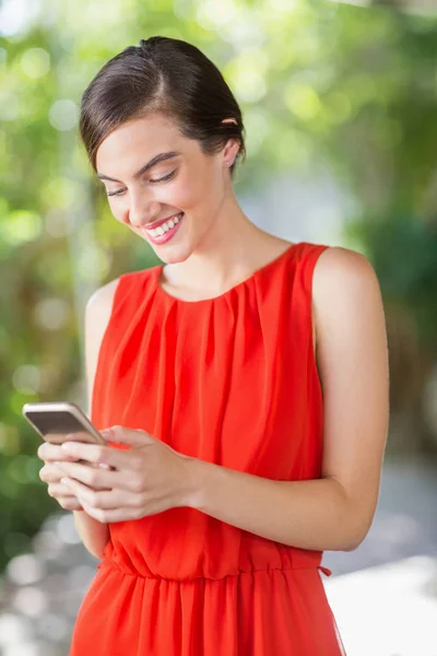 Vrouw die lacht tijdens het gebruik van mobiele telefoon — Stockfoto