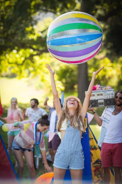 Woman playing with beach ball at campsite — Stock Photo, Image